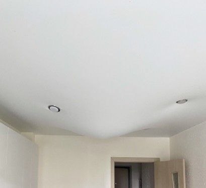 Glatki bijeli stretch strop u uređenom interijeru